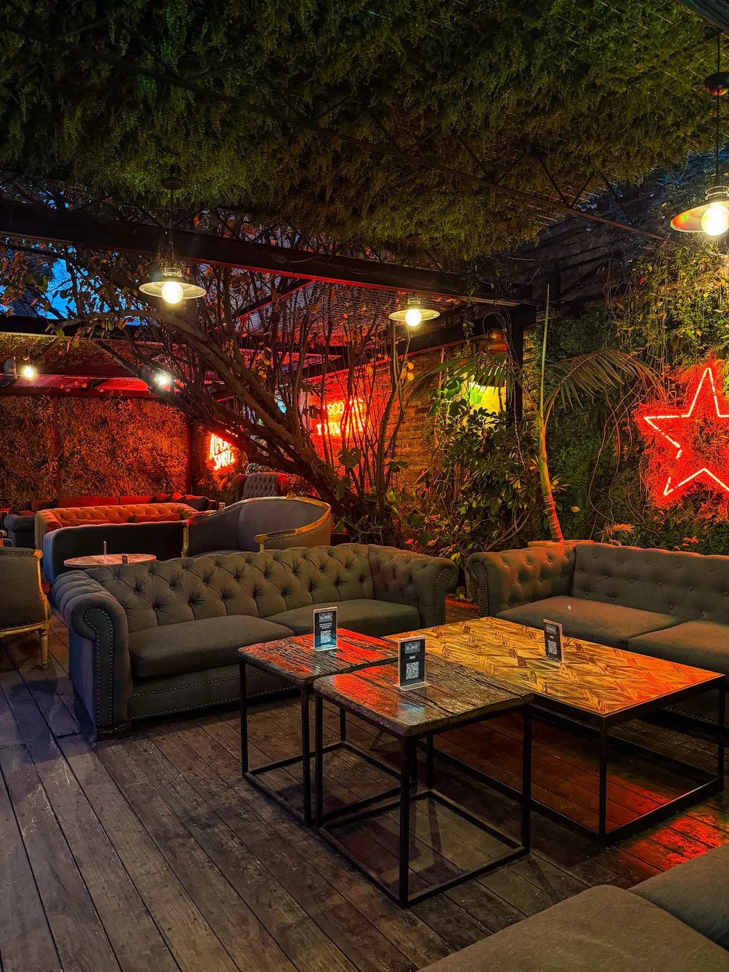 Lounge techado con sillones y neón en Jardín Bellavista