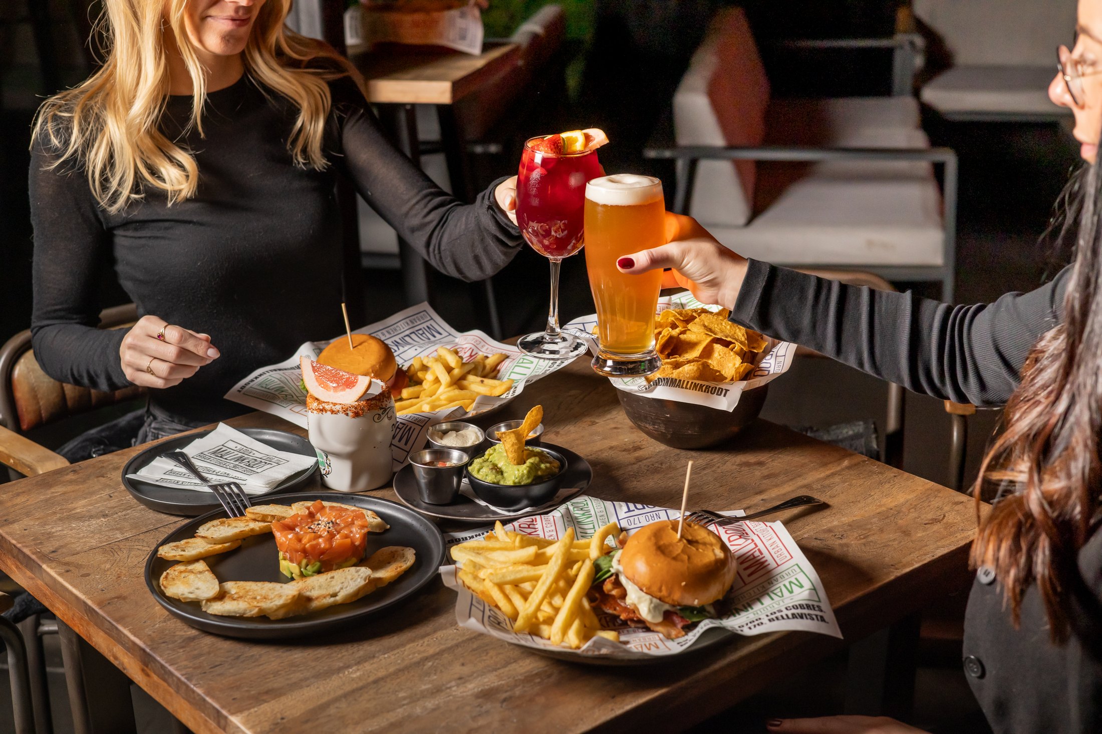Brindis con cerveza artesanal y sangría sobre una mesa servida